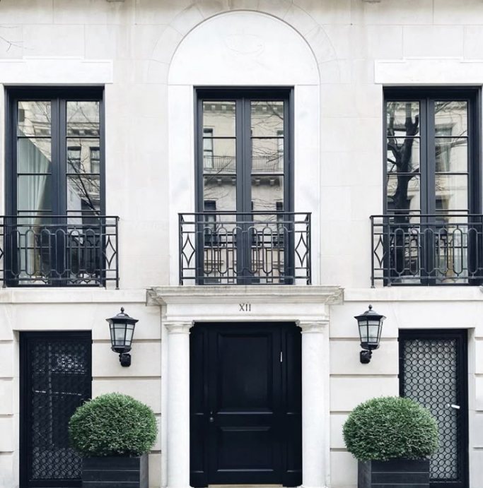 White London townhouse with a black front door and iron balconies